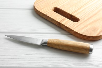 Photo of One sharp knife on white wooden table, closeup