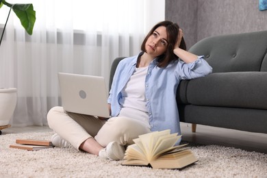 Photo of Overwhelmed woman with laptop sitting on floor indoors