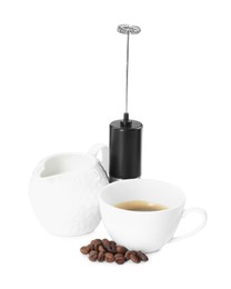 Photo of Mini mixer (milk frother), cup, coffee beans and pitcher isolated on white