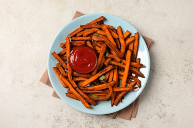 Delicious sweet potato fries served with sauce on light table, top view