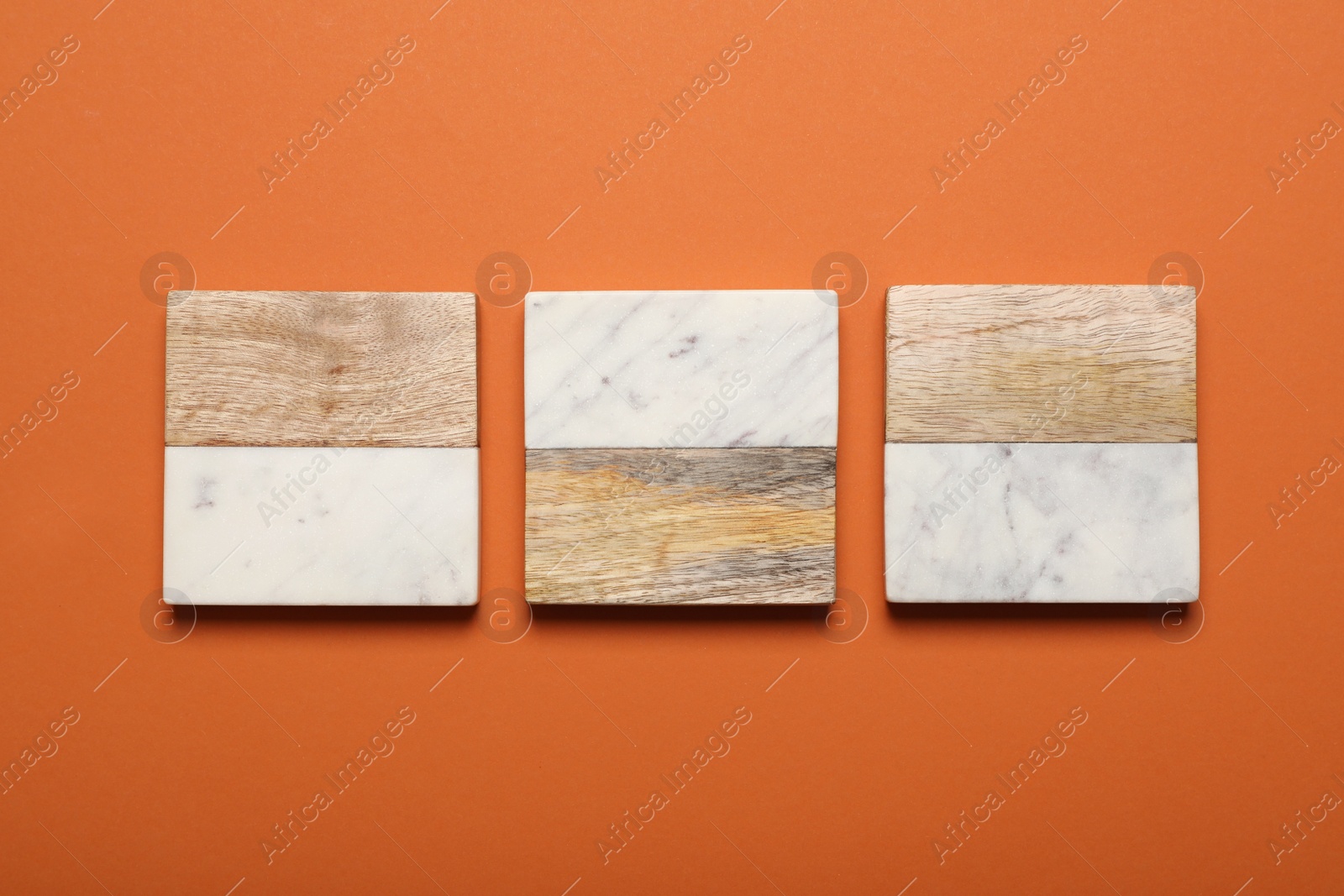 Photo of Stylish cup coasters on orange background, flat lay