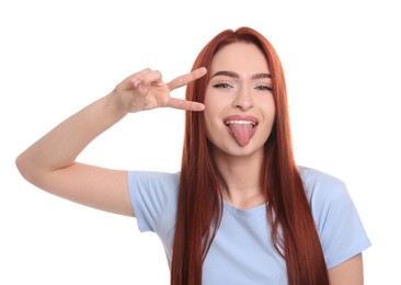 Photo of Beautiful woman with red dyed hair showing tongue on white background