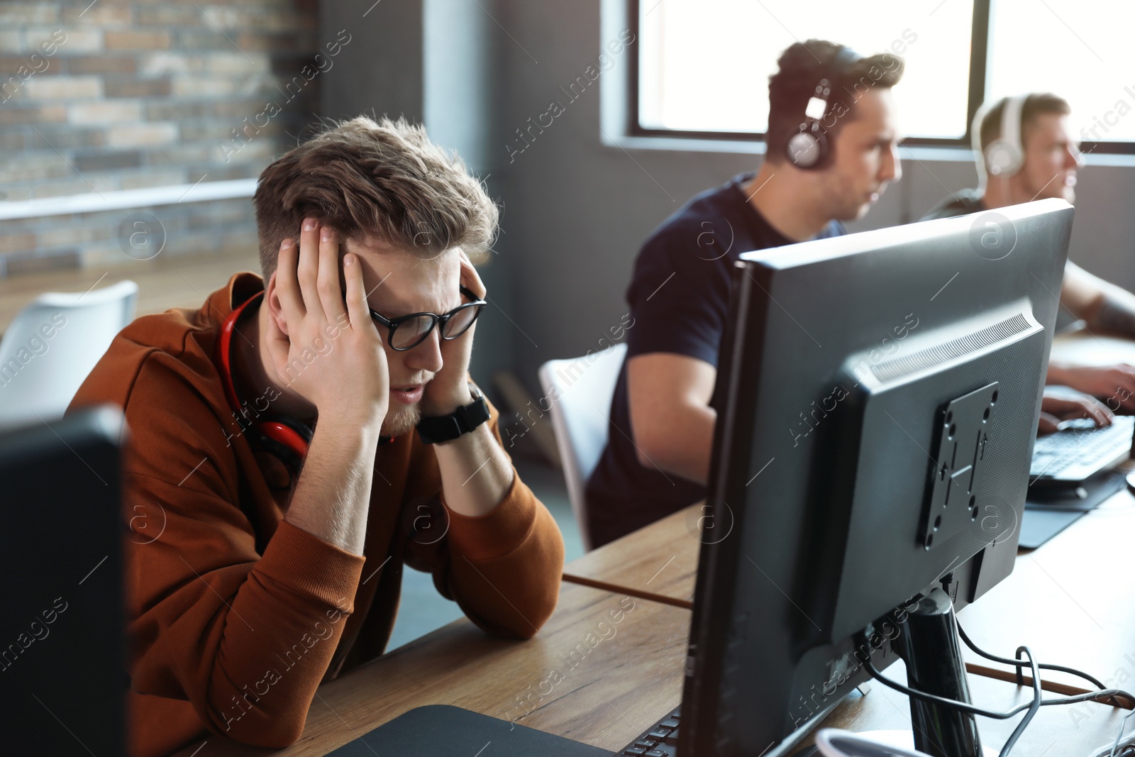 Photo of Men playing video games in internet cafe