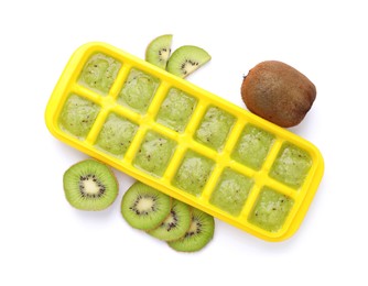 Photo of Kiwi puree in ice cube tray and fresh kiwi fruits isolated on white, top view. Ready for freezing