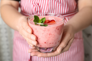 Photo of Woman holding tasty strawberry smoothie with mint, closeup