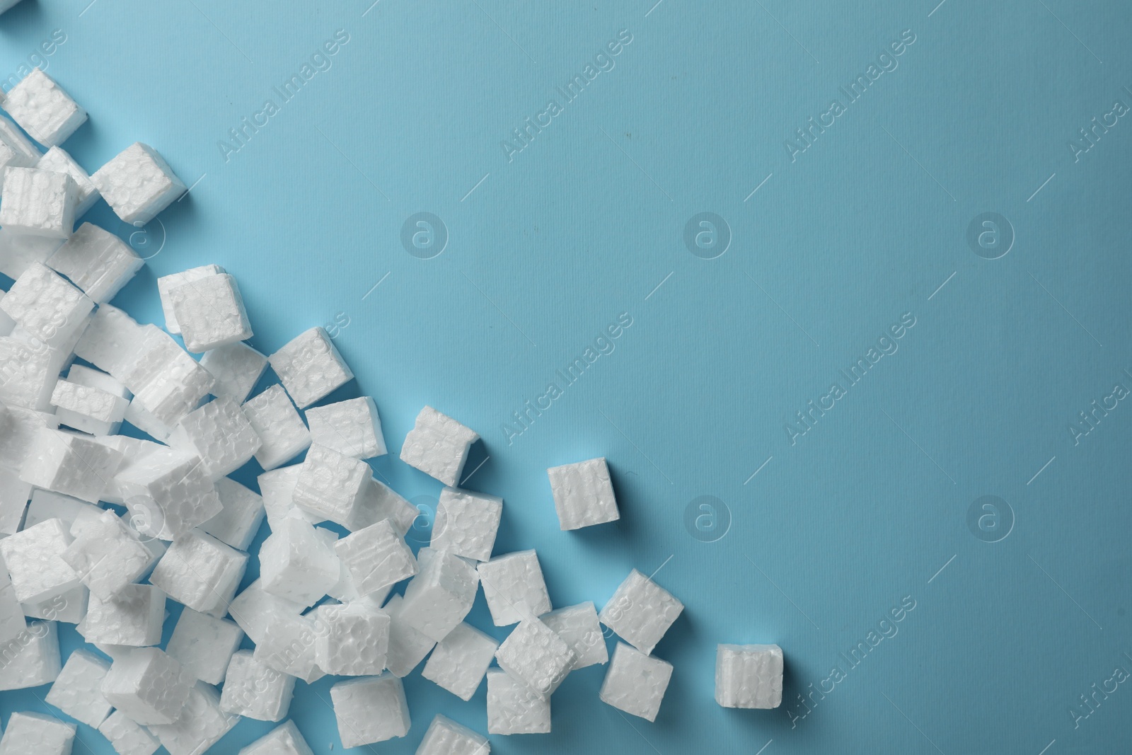 Photo of Many styrofoam cubes on light blue background, flat lay. Space for text