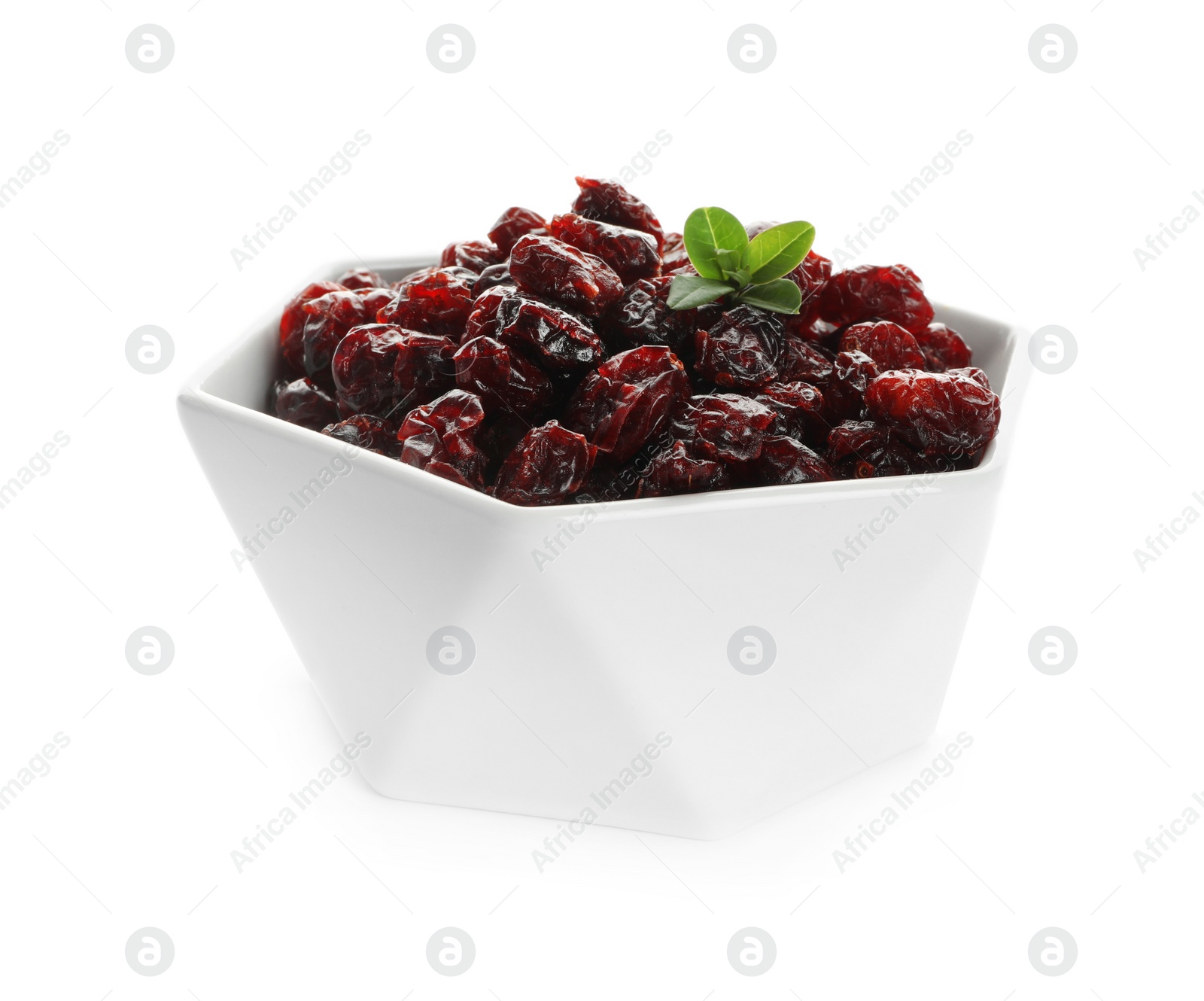 Photo of Tasty dried cranberries and leaves in bowl isolated on white