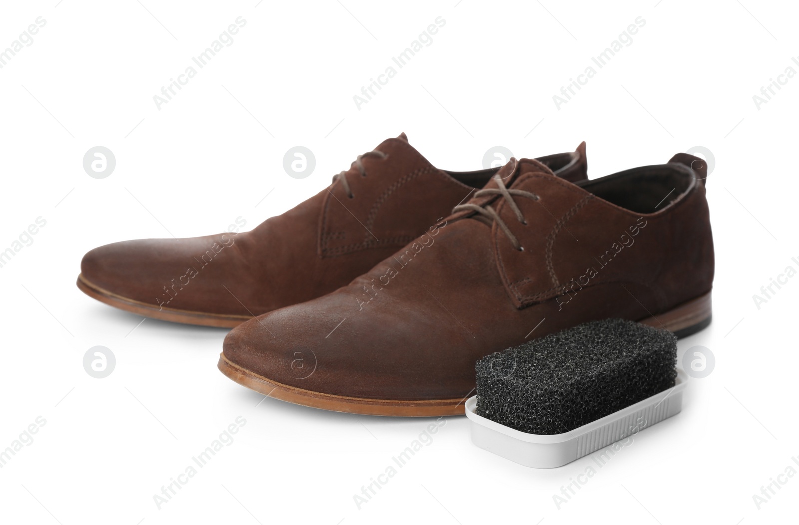 Photo of Stylish footwear and cleaning sponge on white background. Shoes care accessory