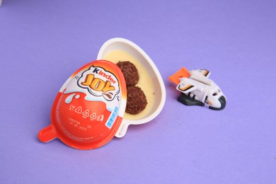 Photo of Sveti Vlas, Bulgaria - June 30, 2023: Kinder Joy Egg with sweet candies and toy on violet background