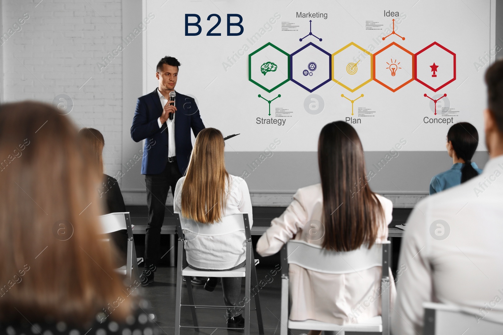 Image of Business trainer giving lecture in conference room with projection screen