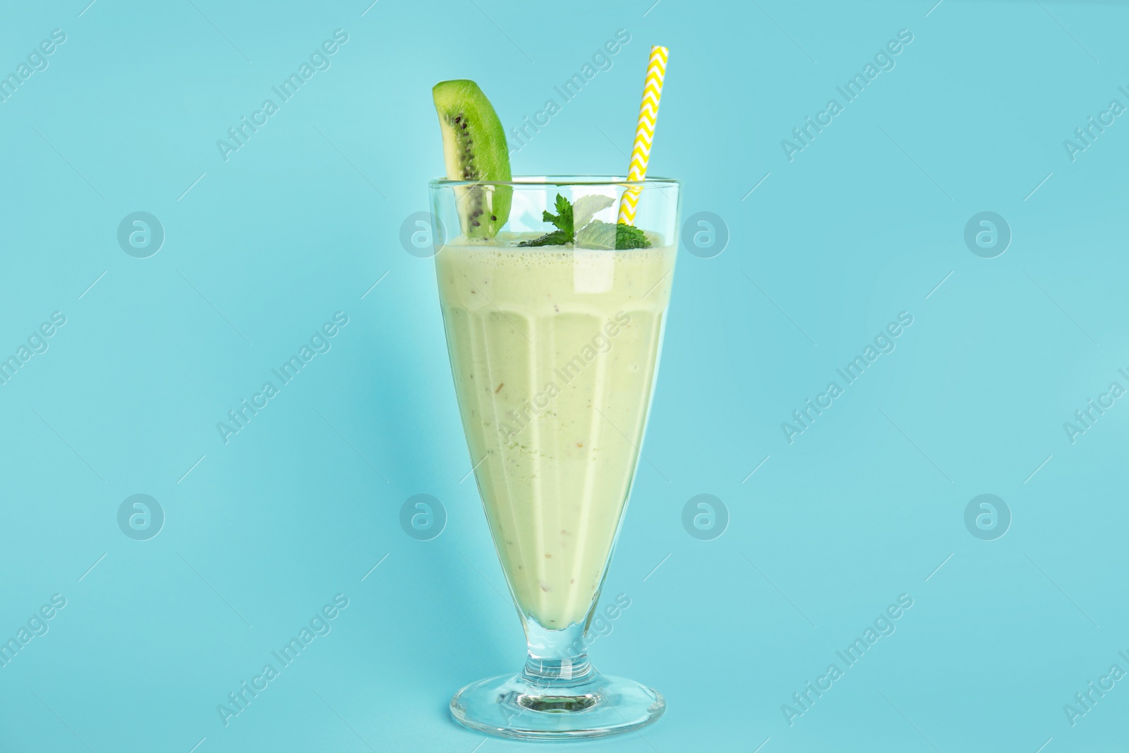 Photo of Tasty fresh milk shake with kiwi on light blue background