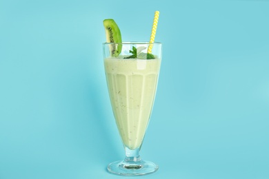 Tasty fresh milk shake with kiwi on light blue background