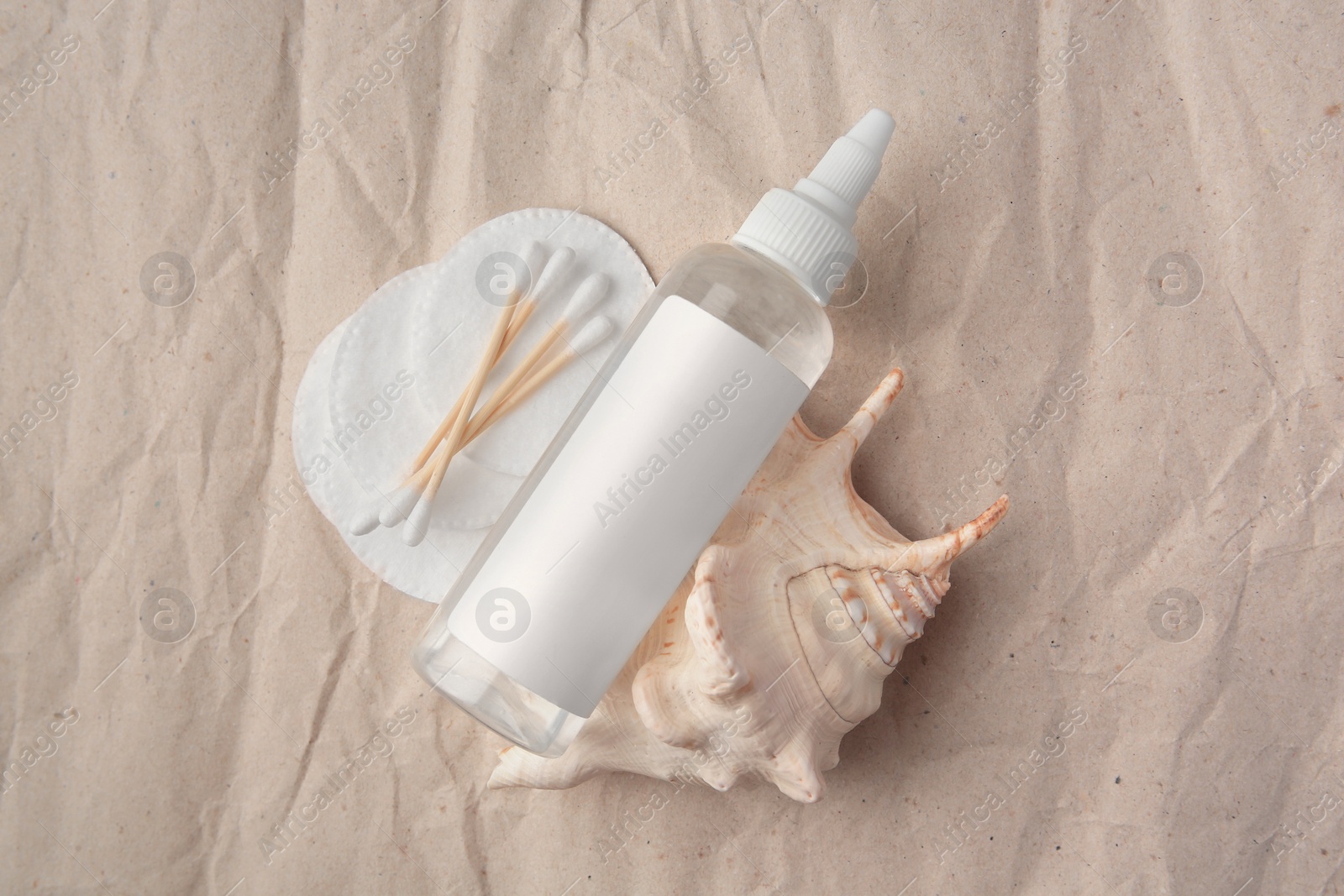 Photo of Flat lay composition with makeup remover and seashell on crumpled paper