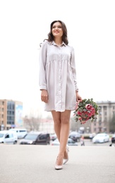 Beautiful woman in elegant shoes walking on street