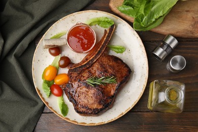 Photo of Tasty grilled meat, rosemary, tomatoes and marinade on wooden table, flat lay