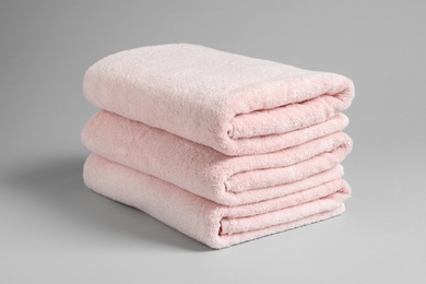 Photo of Stack of fresh towels on light background