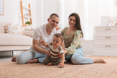 Portrait of happy family with little child at home
