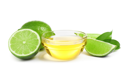 Photo of Lime essential oil in bowl and citrus fruits isolated on white