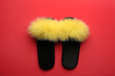 Pair of soft slippers on red background, flat lay