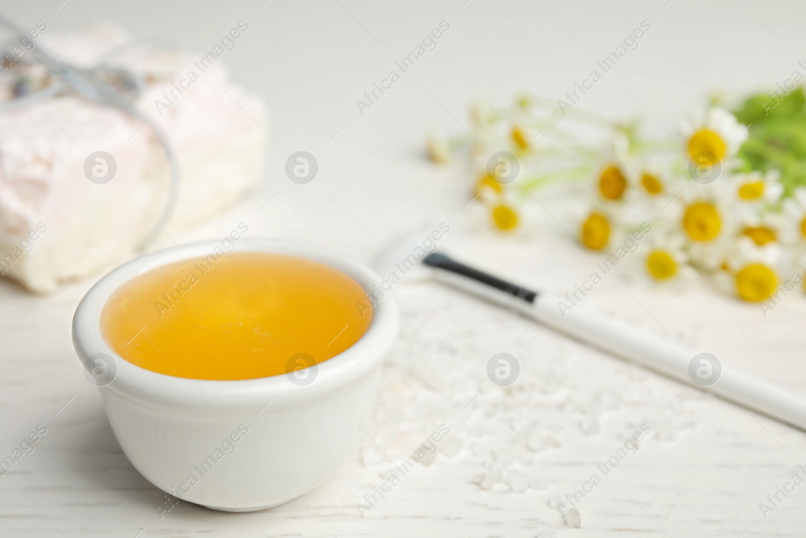 Photo of Professional face mask with  flowers on white wooden table. Space for text