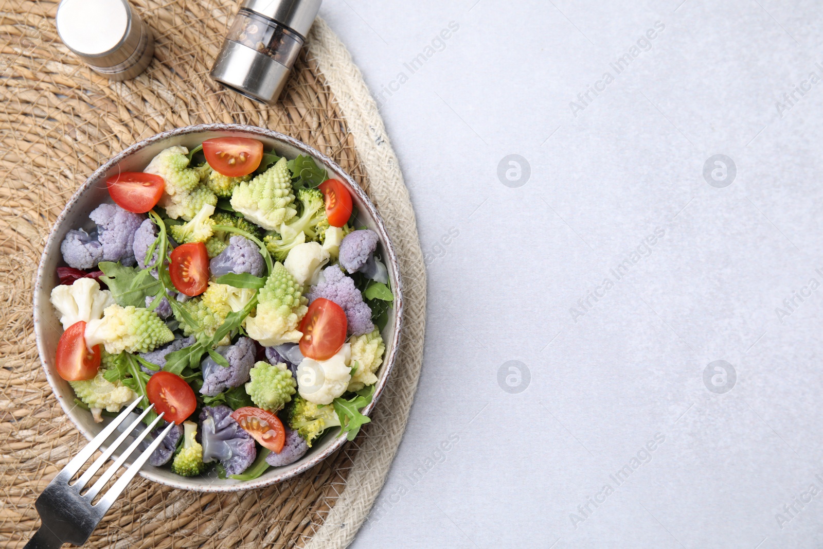 Photo of Delicious salad with cauliflower and tomato served on white table, flat lay. Space for text