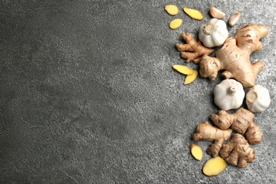 Photo of Flat lay composition with ginger, fresh garlic and space for text on grey table. Natural cold remedies