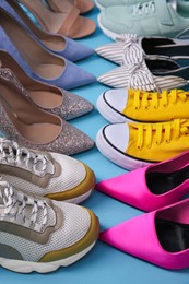 Many different shoes on turquoise background, closeup. Diversity concept