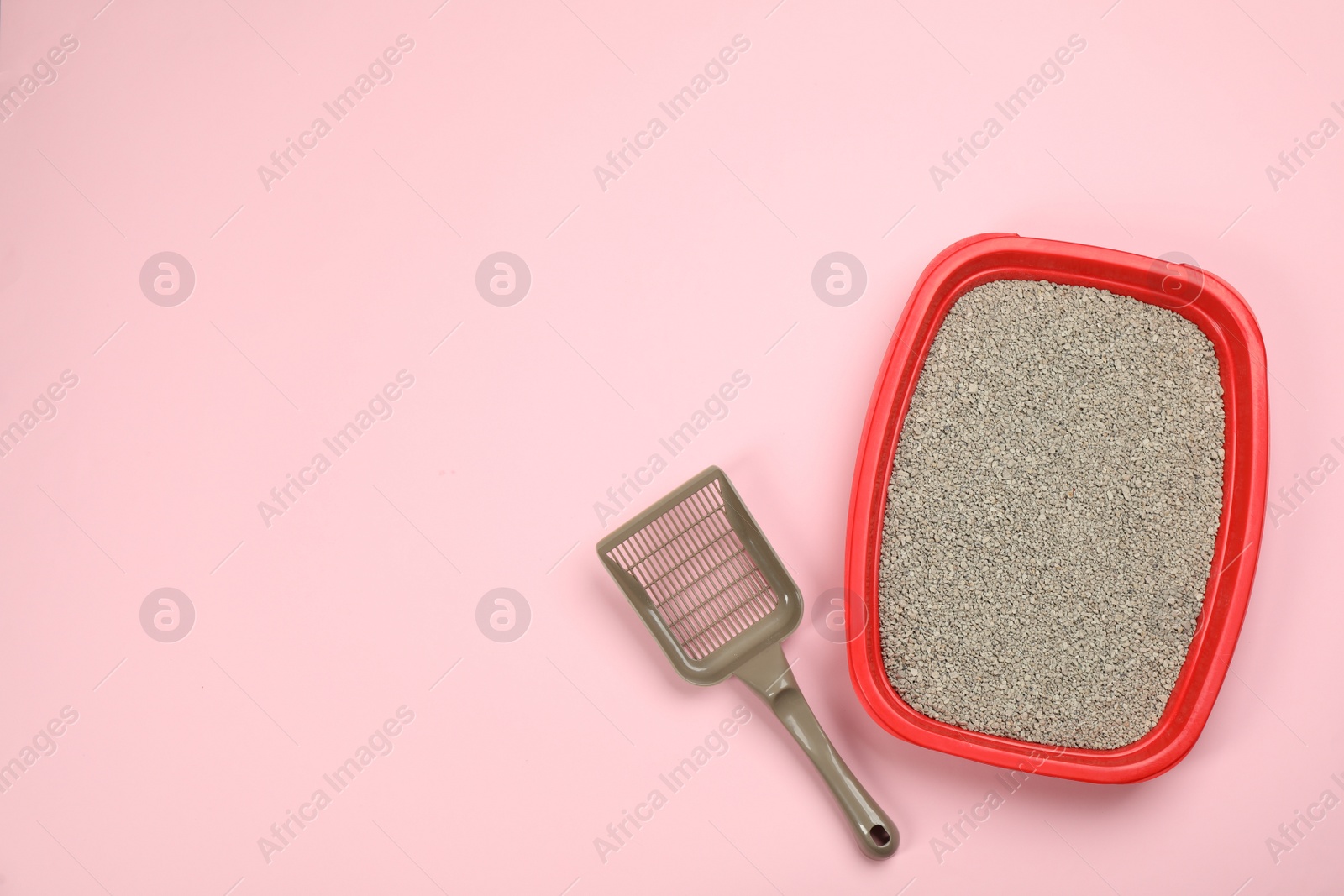 Photo of Cat litter tray with filler and scoop on pink background, flat lay. Space for text