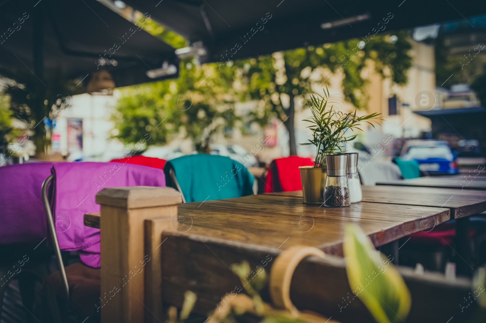 Photo of Wooden table and comfortable chairs in outdoor cafe