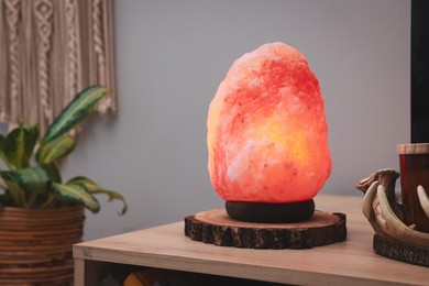 Himalayan salt lamp on wooden table indoors