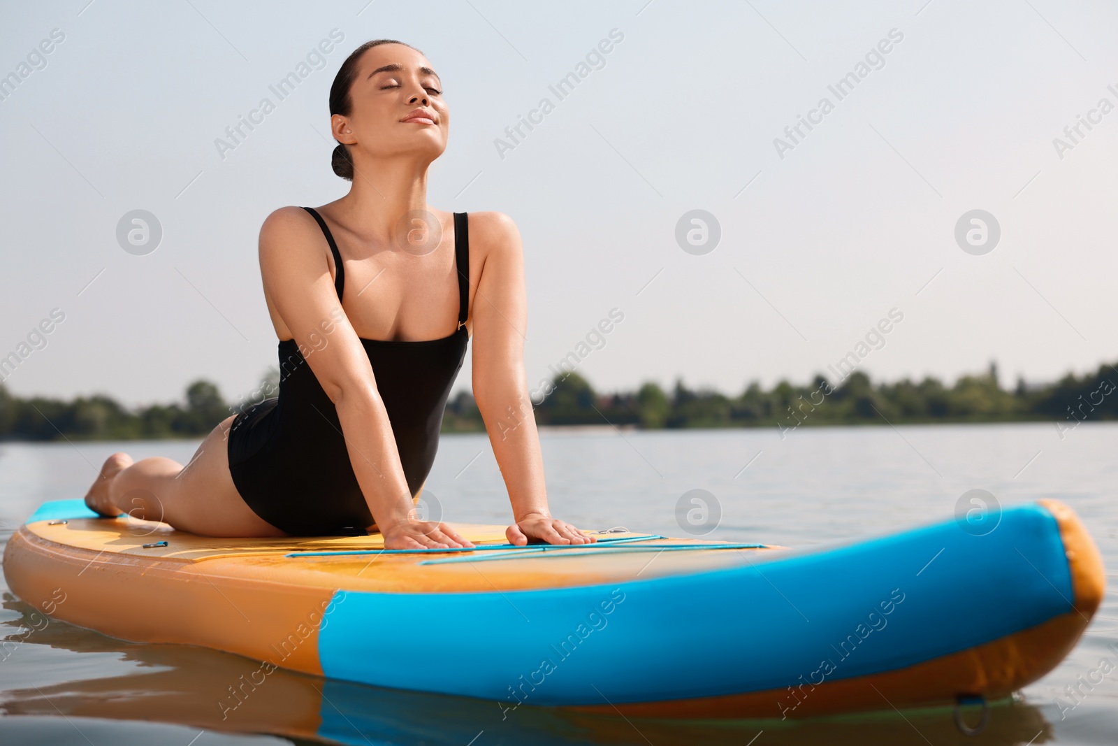 Photo of Woman practicing yoga on SUP board on river