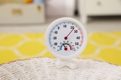 Photo of Round hygrometer with thermometer on mat in room