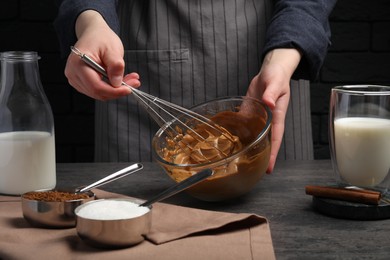 Photo of Woman whipping cream for dalgona coffee at grey table, closeup