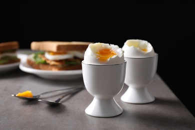 Photo of Soft boiled eggs served on grey table. Space for text
