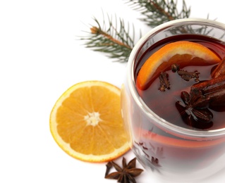 Photo of Glass of mulled wine with fir branch and orange isolated on white. Space for text