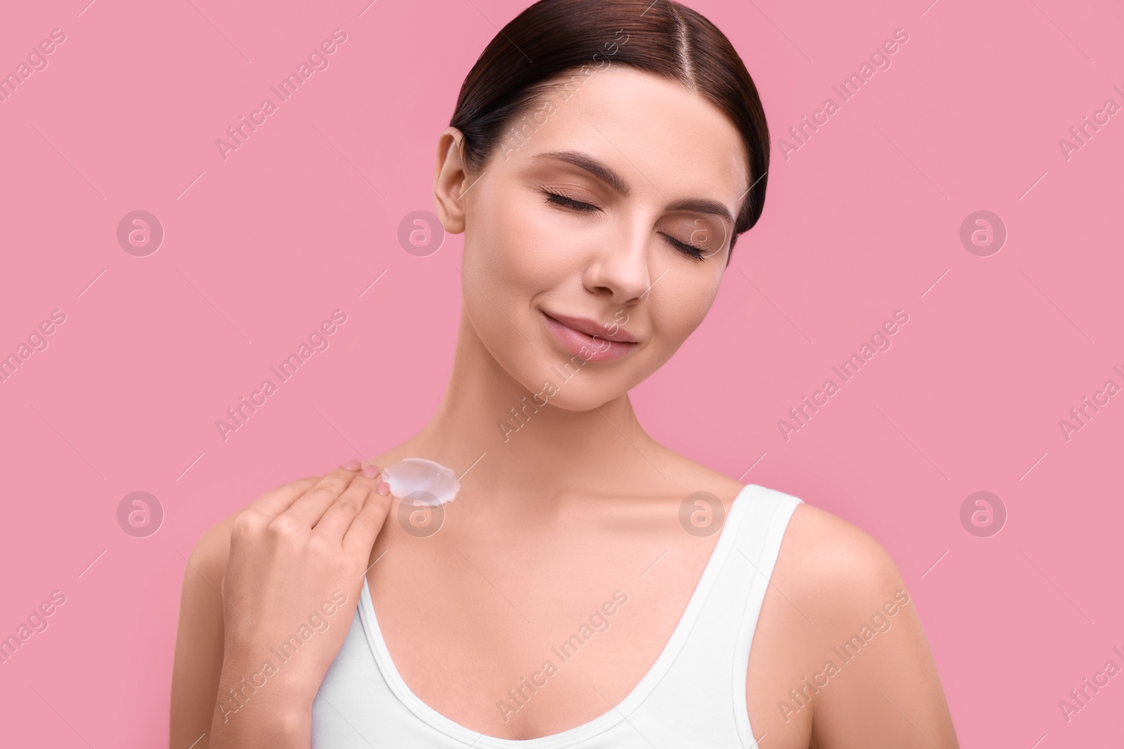 Photo of Beautiful woman with smear of body cream on pink background