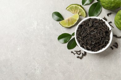 Photo of Dry bergamot tea leaves and fresh fruits on light grey table, flat lay. Space for text