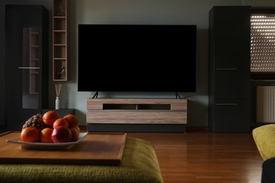 Stylish room with beautiful furniture and TV set on table. Interior design