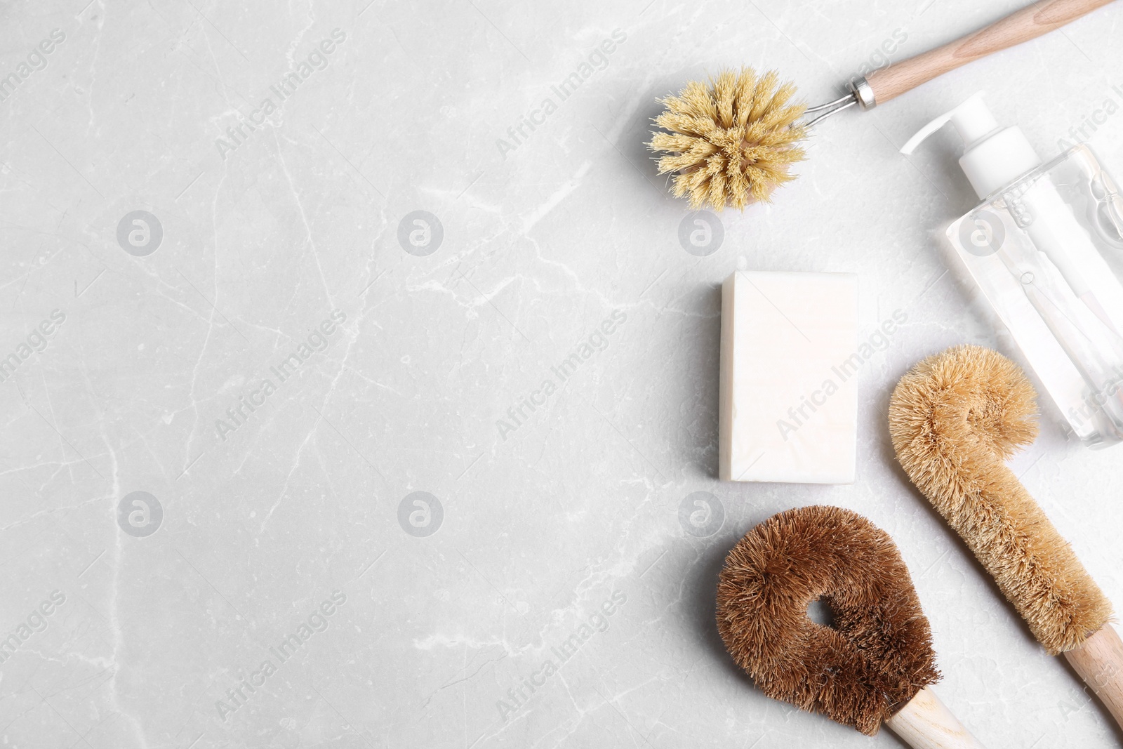 Photo of Cleaning product and tools on grey table, flat lay with space for text. Dish washing supplies