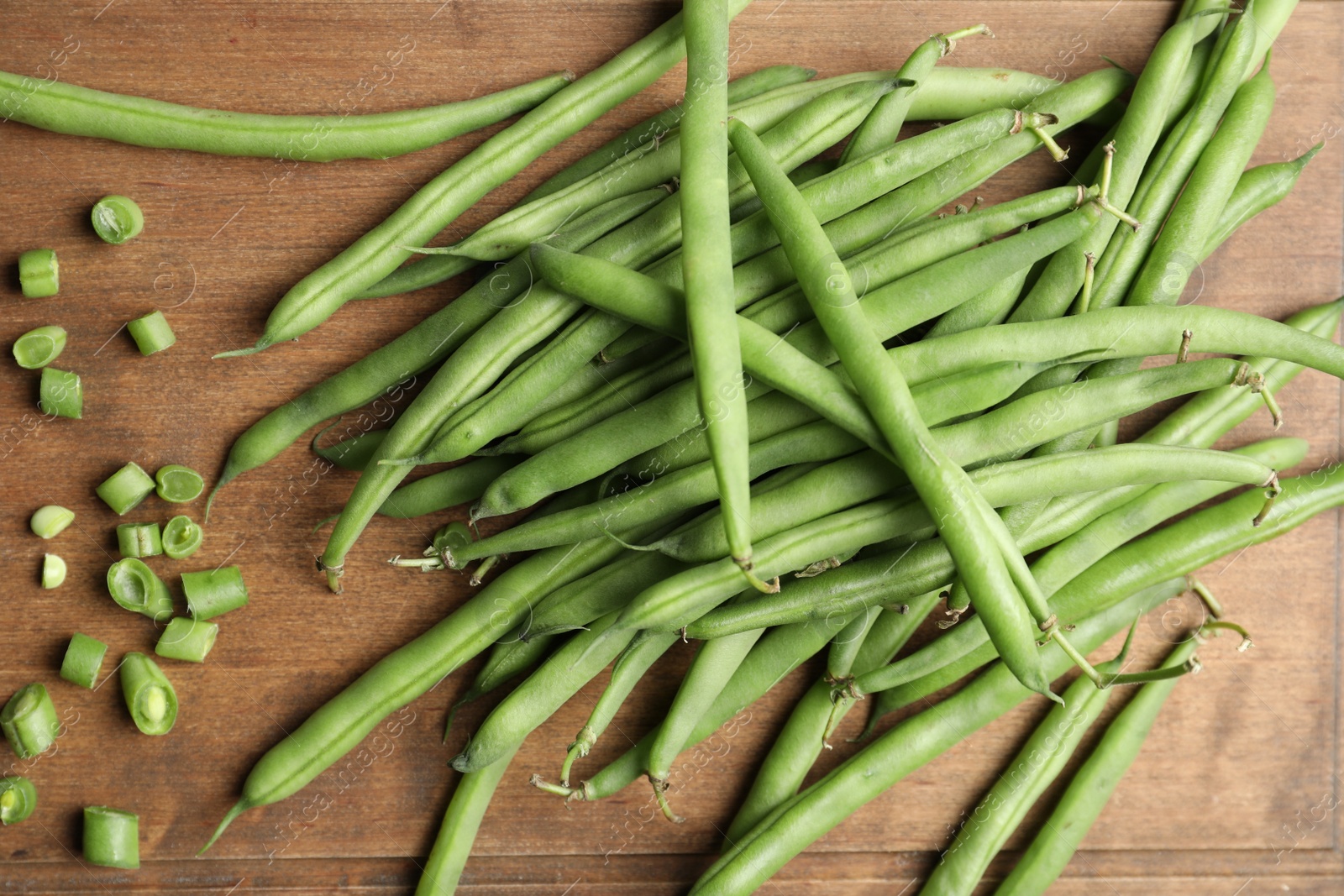 Photo of Fresh green beans on wooden board, flat lay