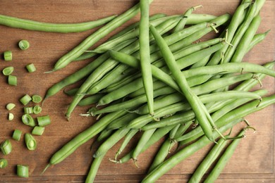 Photo of Fresh green beans on wooden board, flat lay
