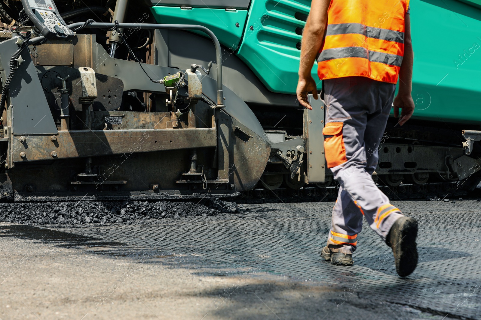 Photo of Worker laying new asphalt with paver, closeup. Road repair