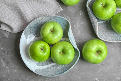 Composition with fresh green apples on grey table, top view