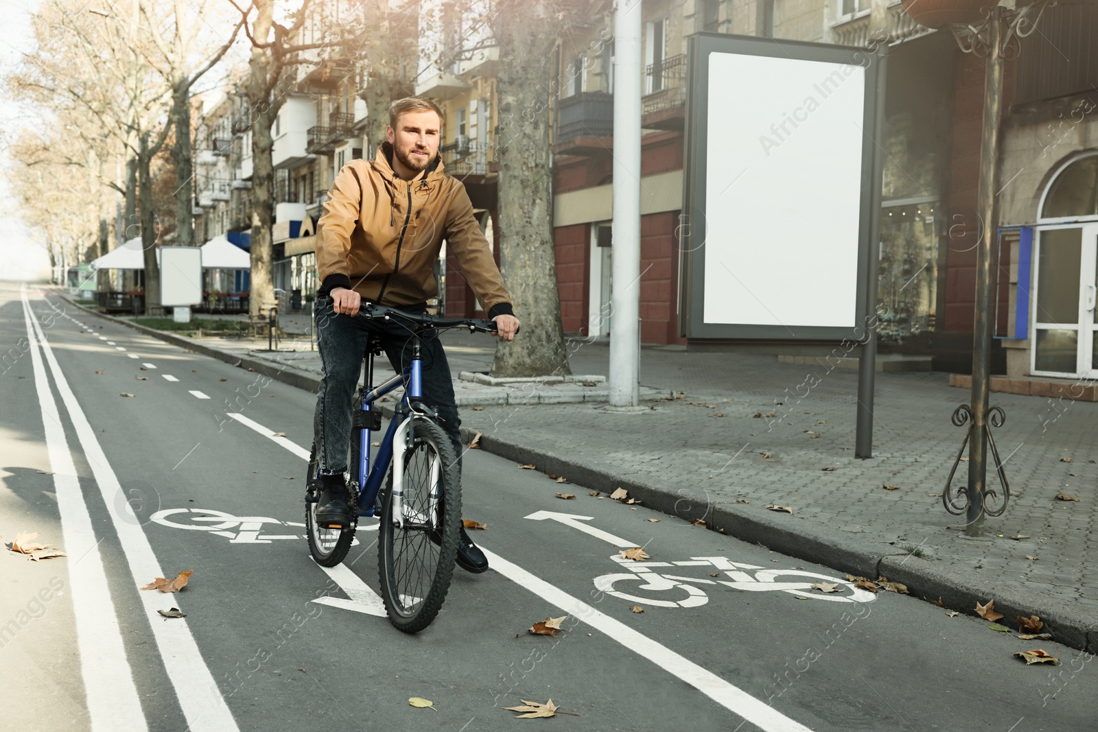 Photo of Happy handsome man riding bicycle on lane in city