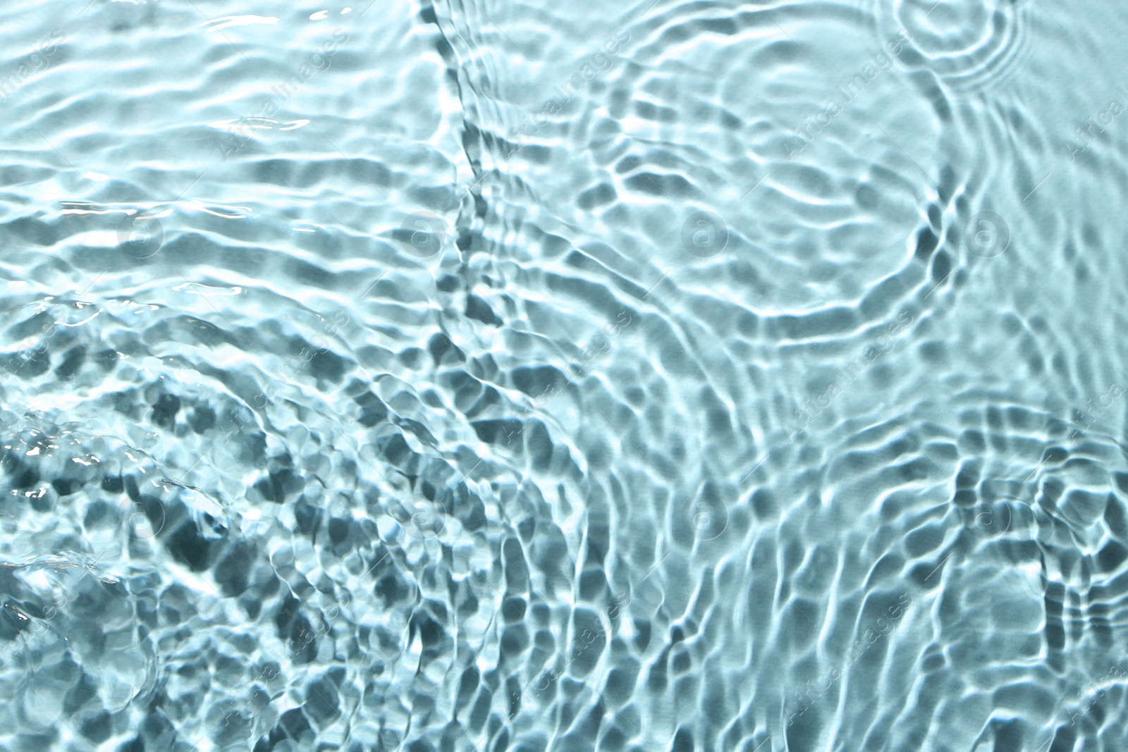 Image of Rippled surface of clear water on light blue background, top view