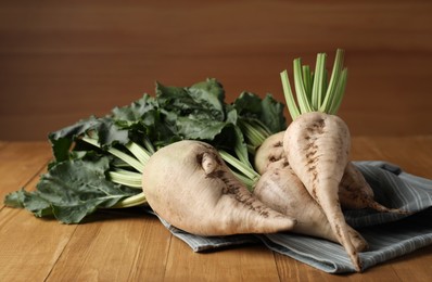 Photo of Fresh sugar beets with leaves on wooden table