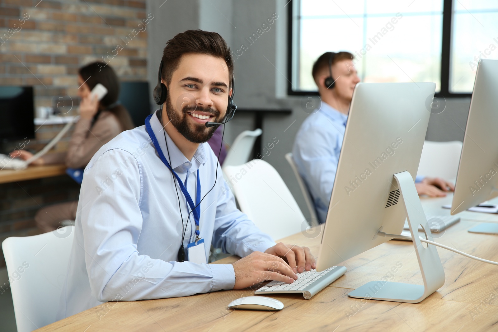 Photo of Technical support operator working with colleagues in office