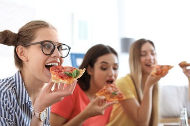 Photo of Young people having fun party with delicious pizza indoors