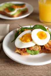 Photo of Sandwich with egg, bacon and spinach served on wooden table, closeup