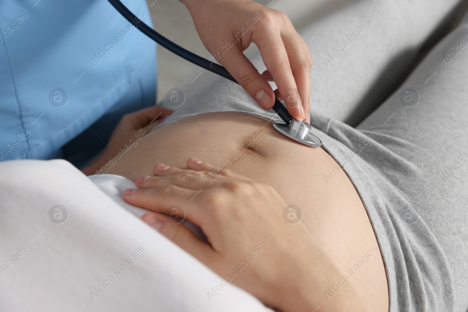 Photo of Doctor examining pregnant woman in hospital, closeup